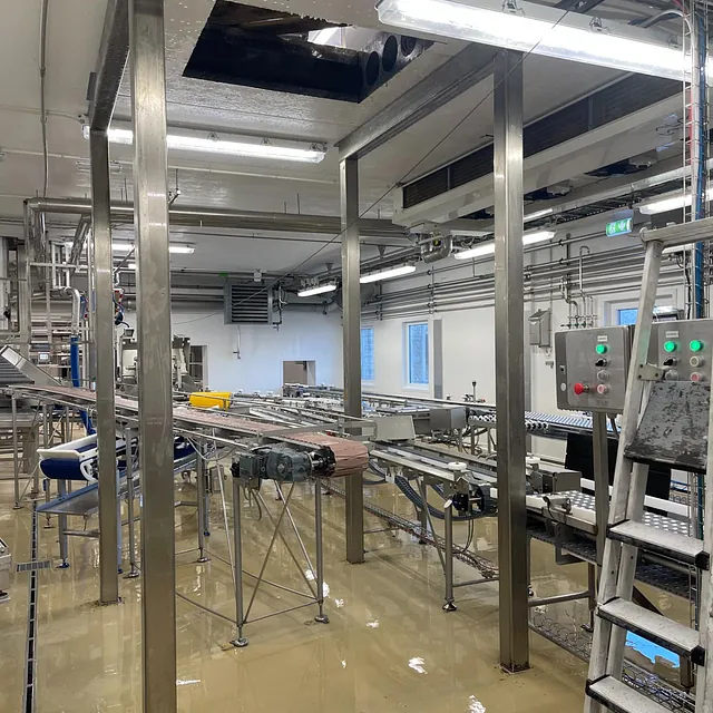 Produksjonslokale med åpen takåpning og stålkonstruksjon under arbeid.