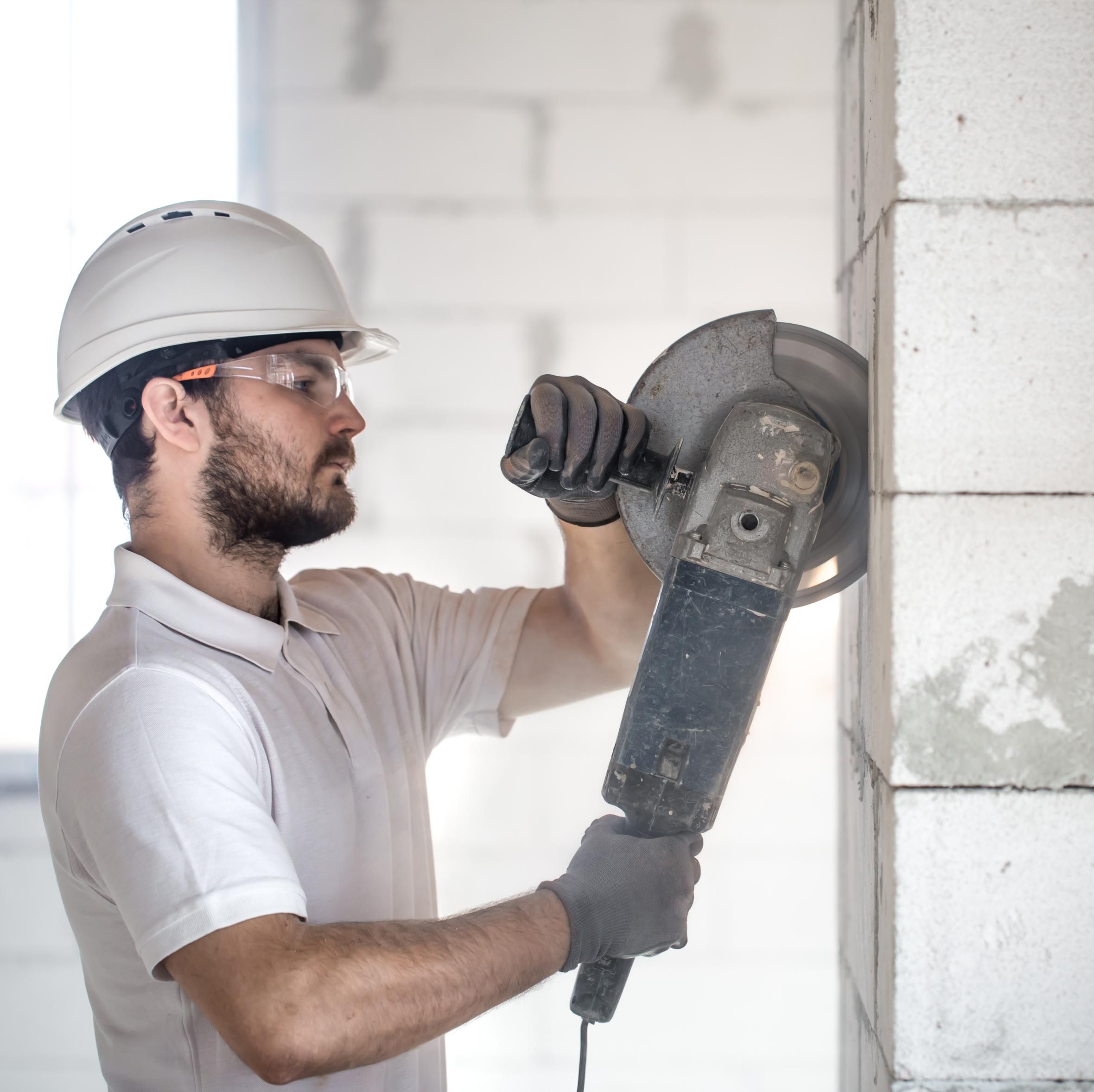 Man bruker betongsag på betongvegg